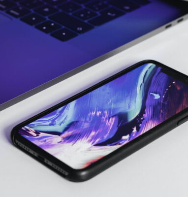 Smartphone mit lila Hintergrundbild